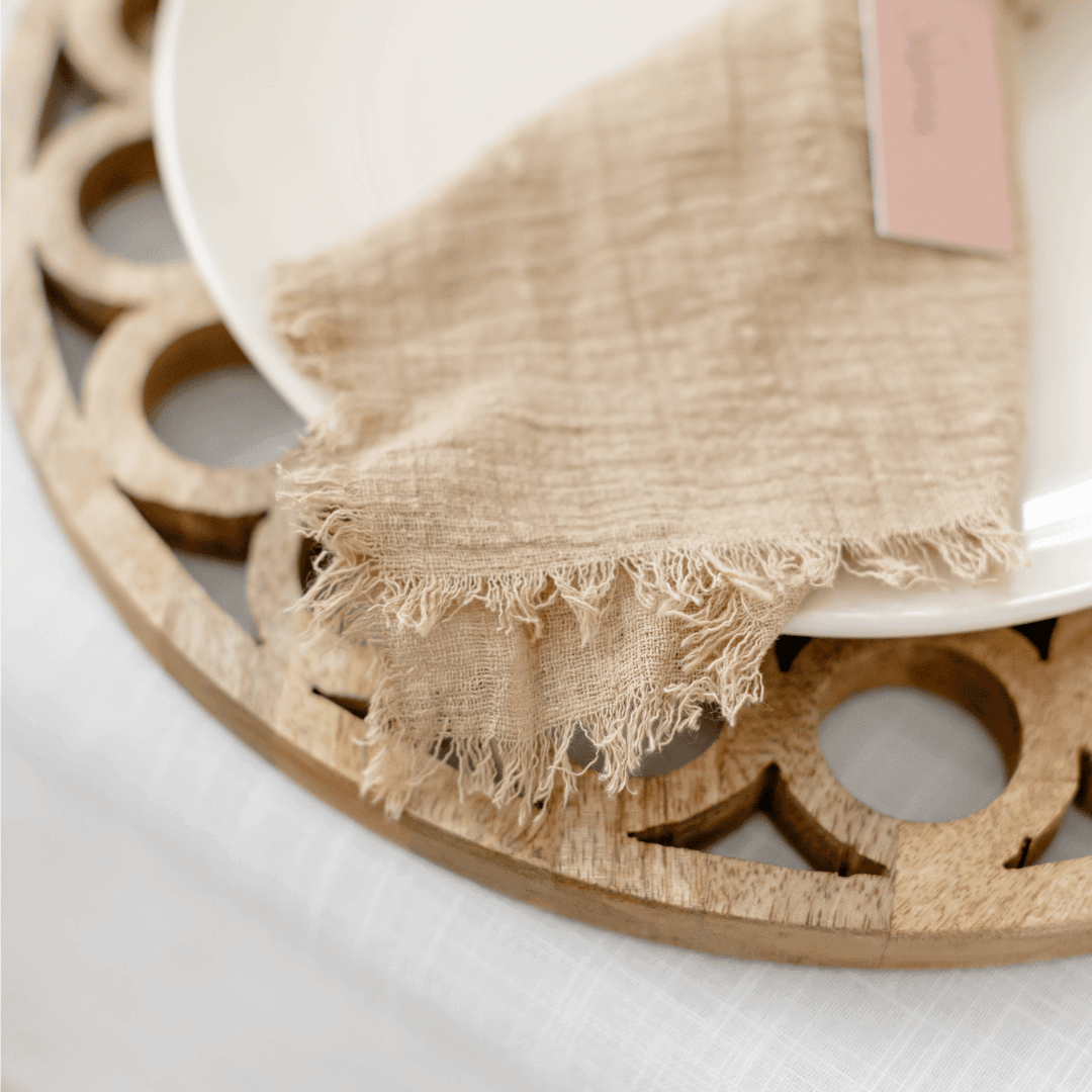 wood decorative charger plate for dining table decor with taupe linen napkin on a plate