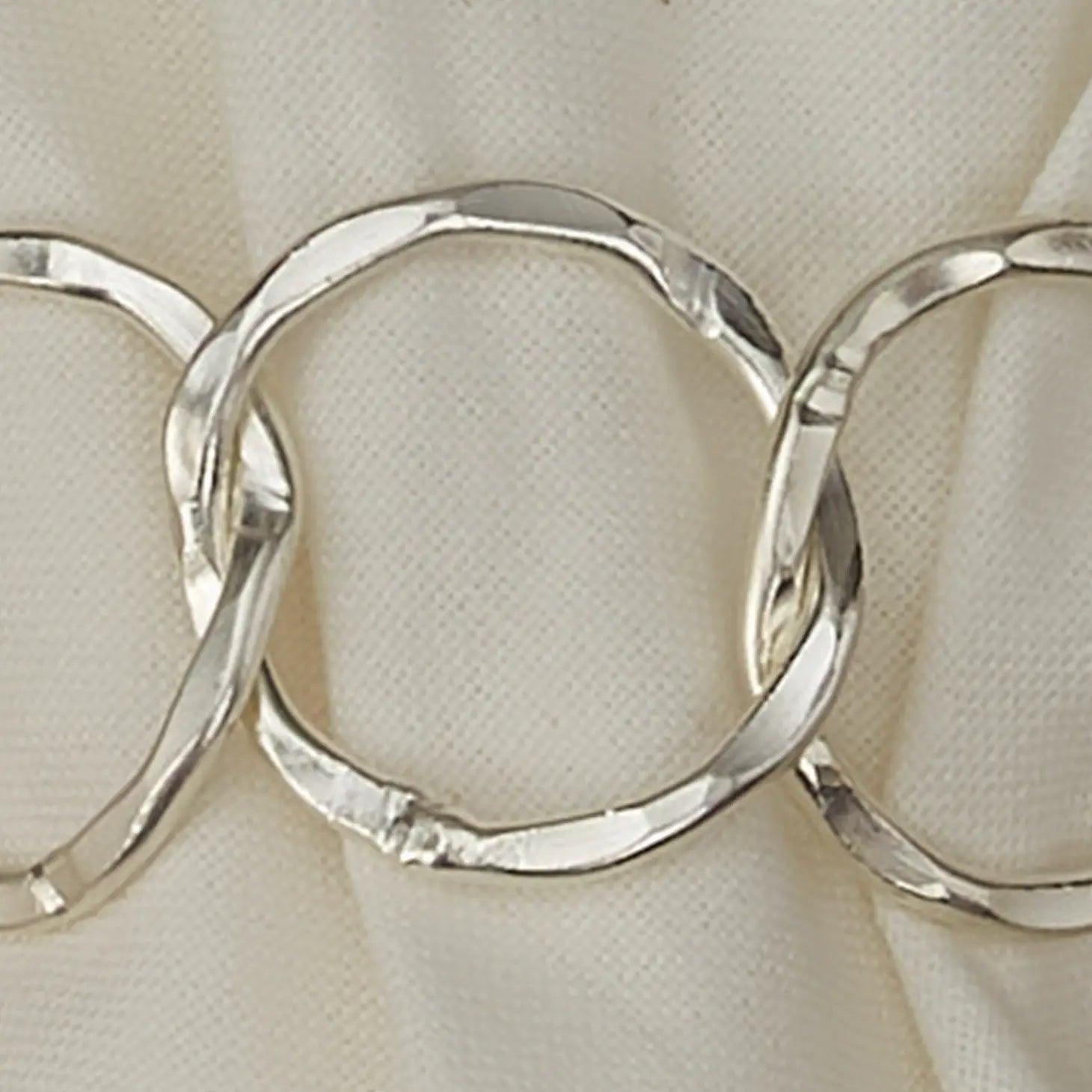 close up of silver chainlink metal napkin ring white napkin