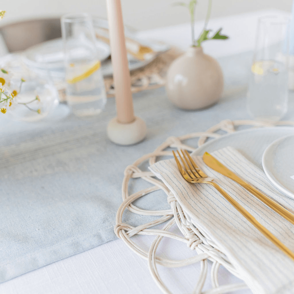 one candle from the summerville oasis candlestick duo peaking into a simple tablescape