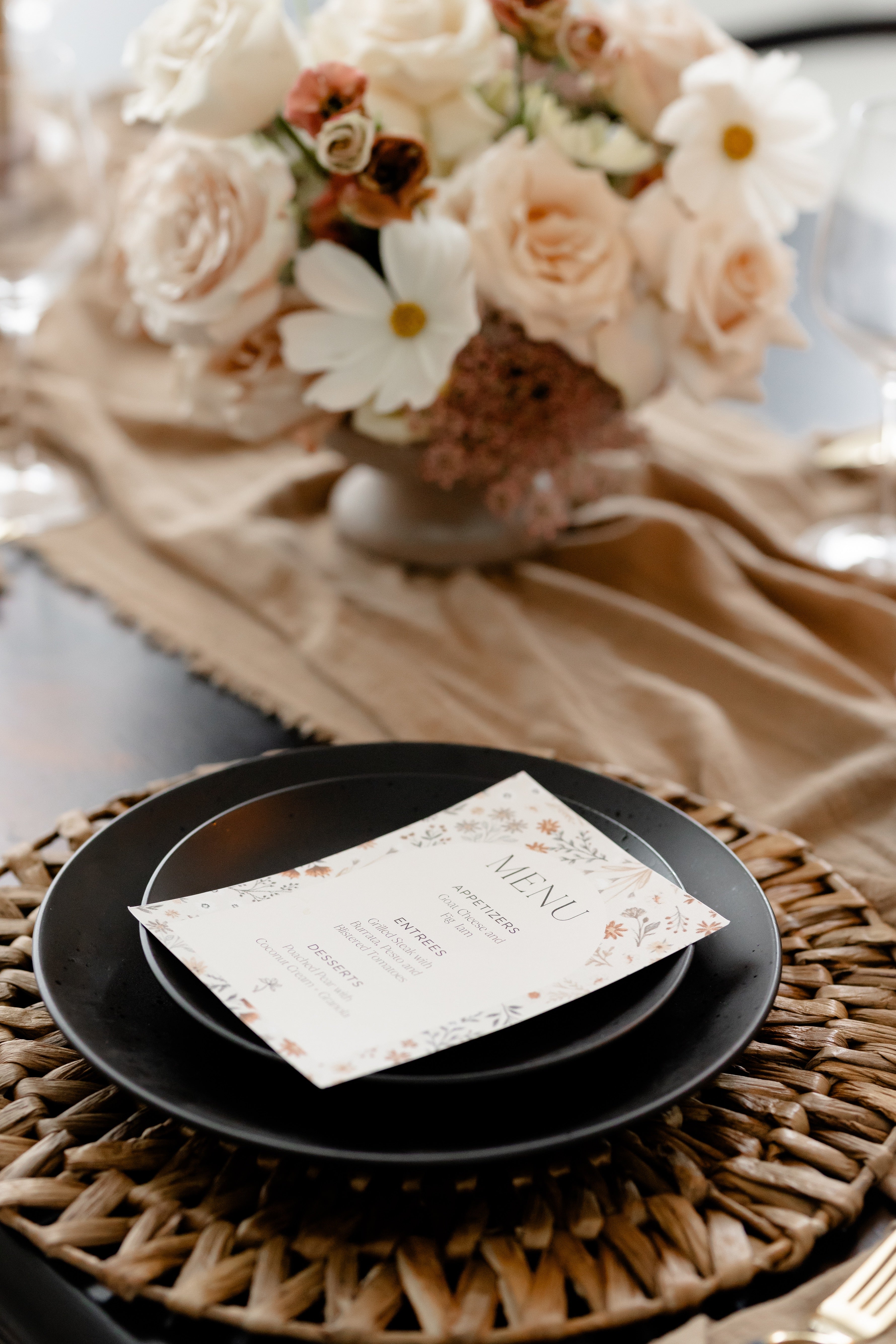 angled photo of table setting with printable menu atop blurred florals in background