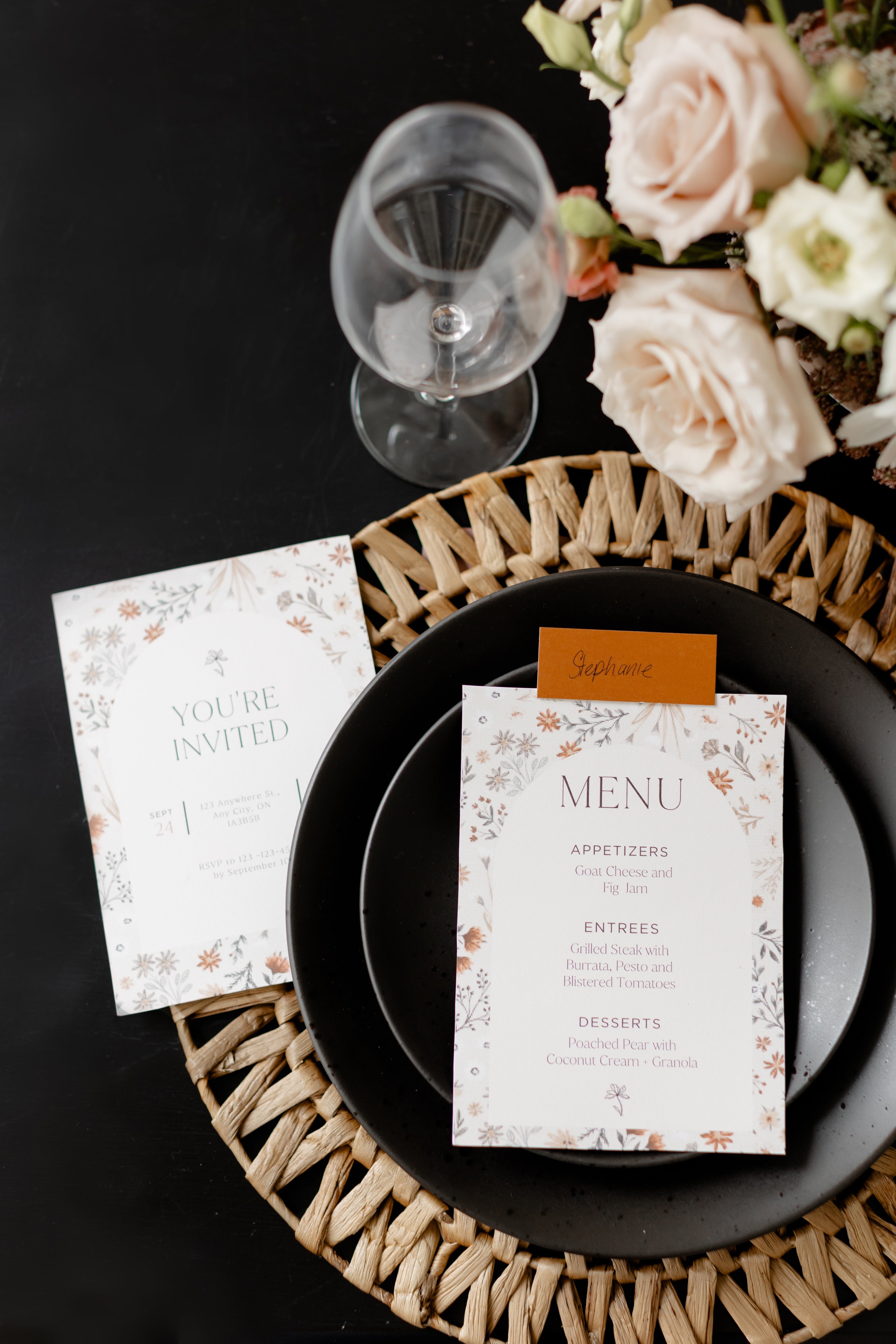 table setting with woven charger black plates with printable menu ontop the plate and printable invite to the left on table