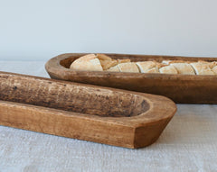 two  mango wood baguette holders sitting on an oatmeal gauze table runner