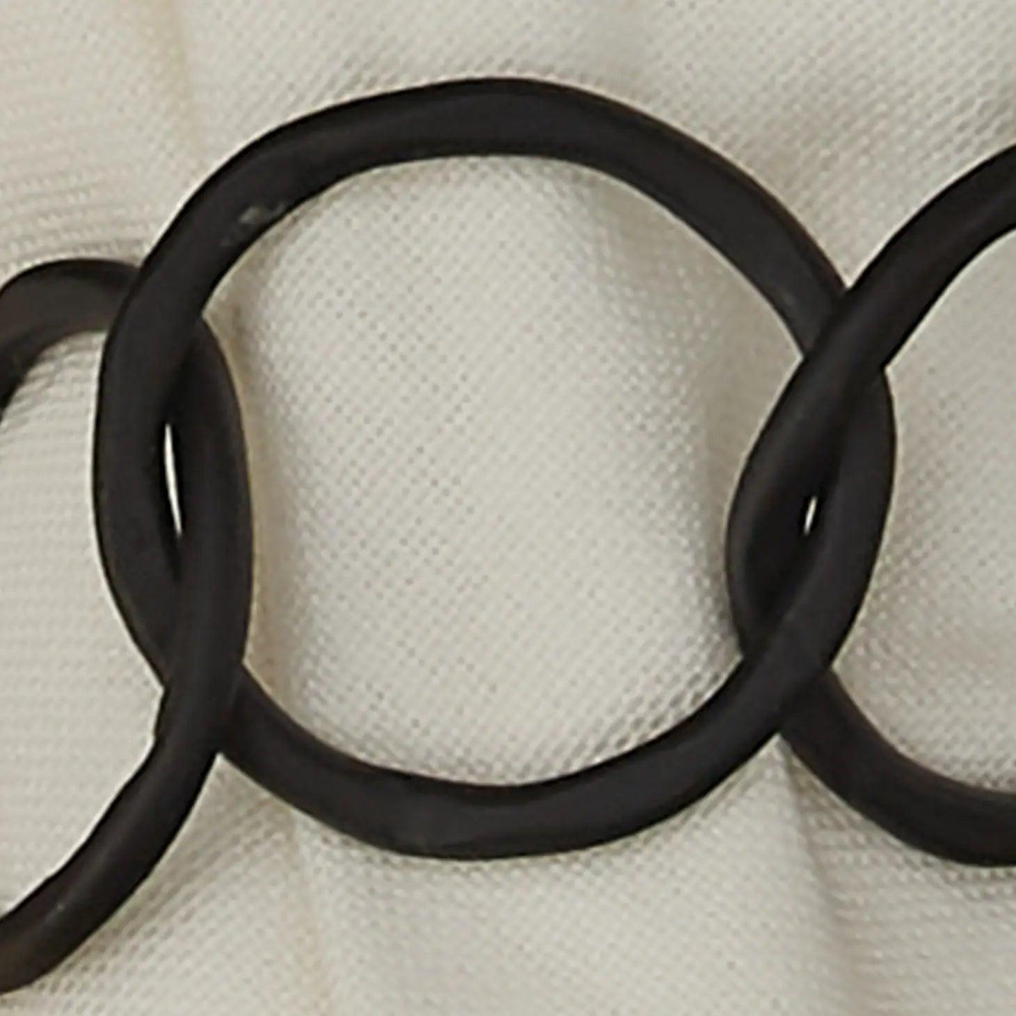 close up of black chainlink metal napkin ring on white napkin