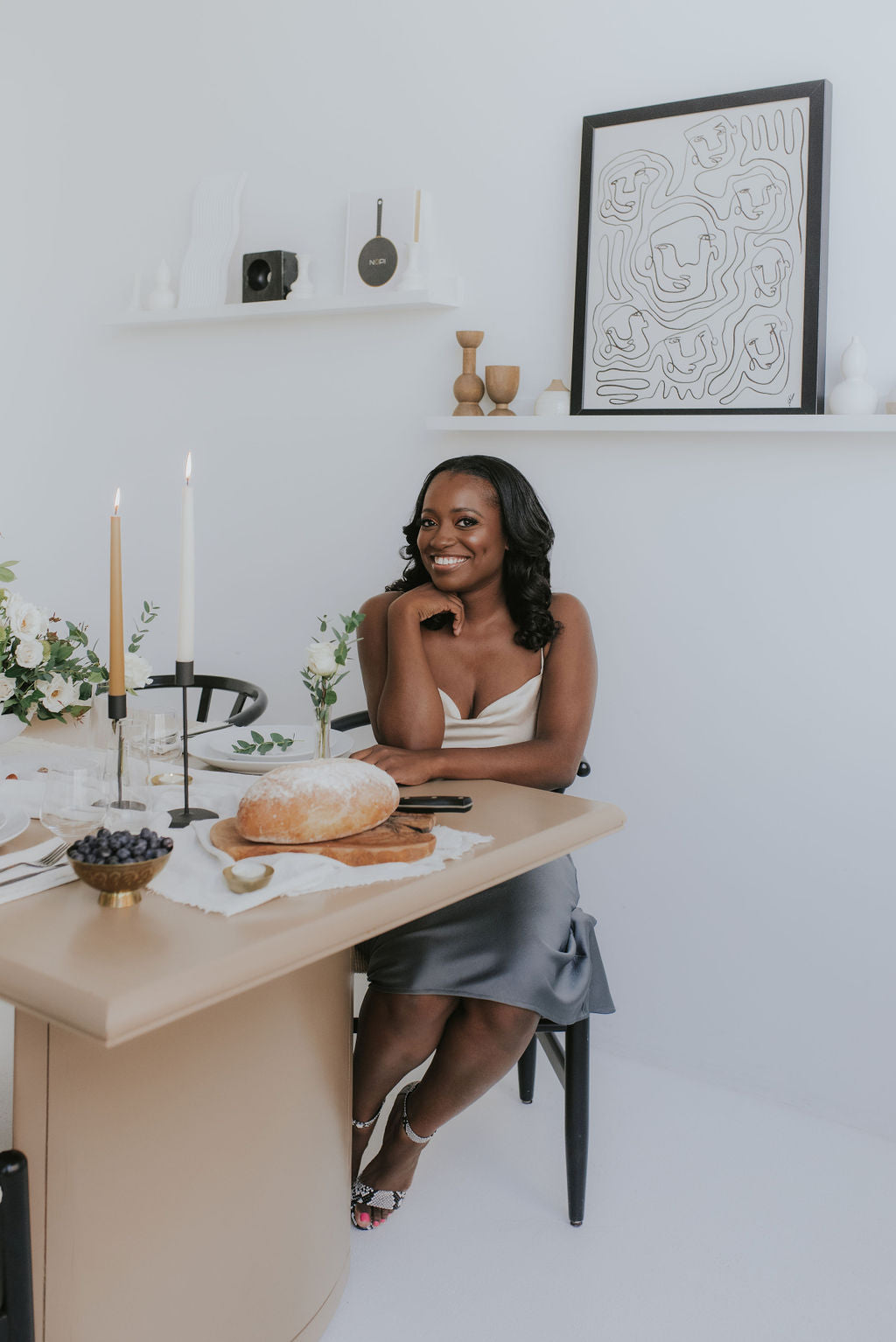 founder stephanie commisso smiling and sitting at table with onoir taper candles holders and candles