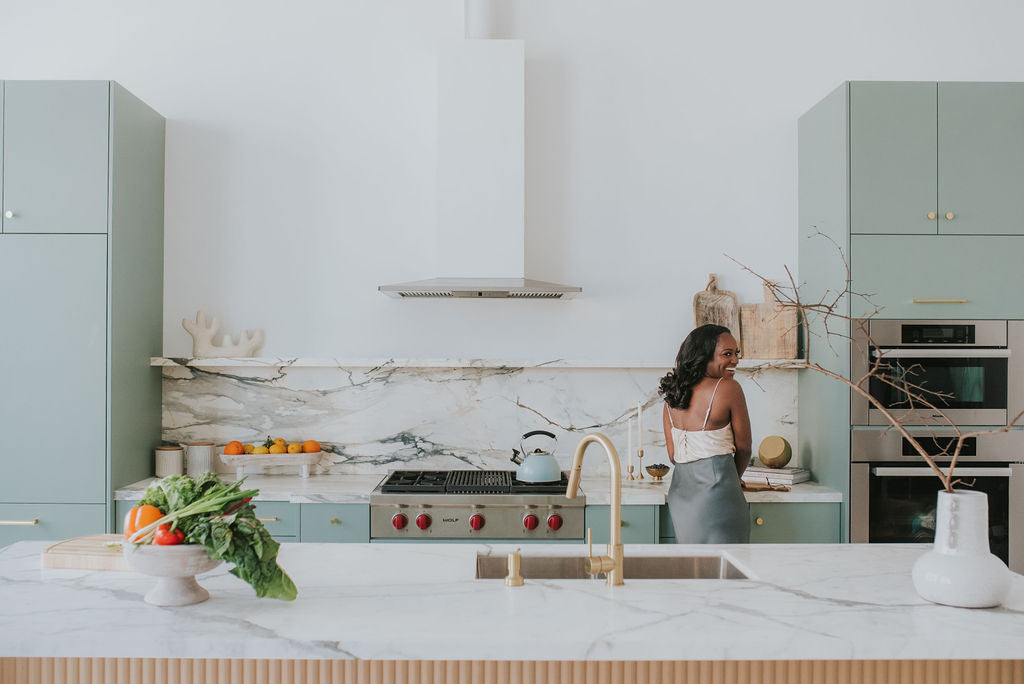 woman looking over her shoulder at camera in beautiful kitchen with white marble countertops