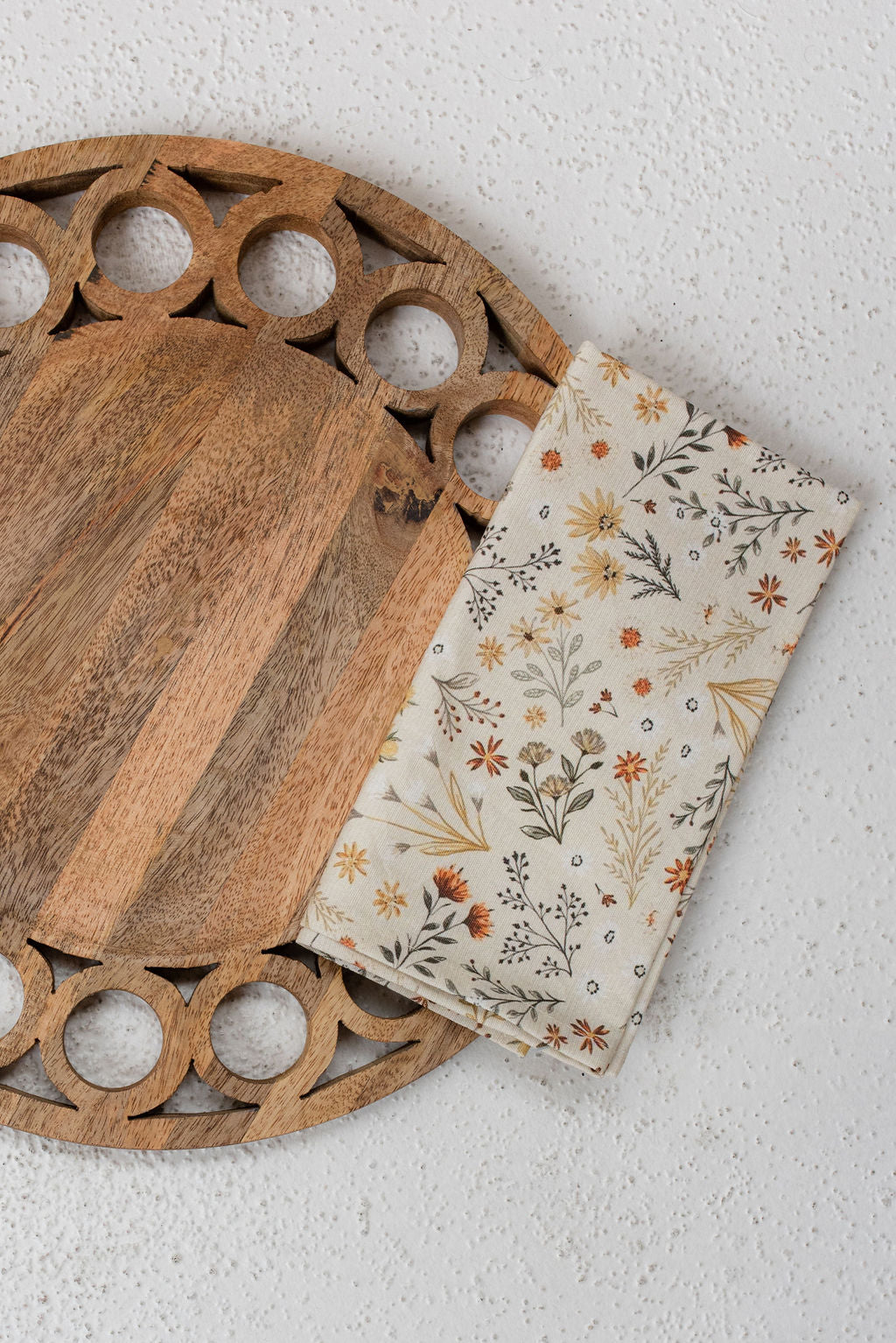 modern circular wooden tray with fall meadow napkin placed ontop