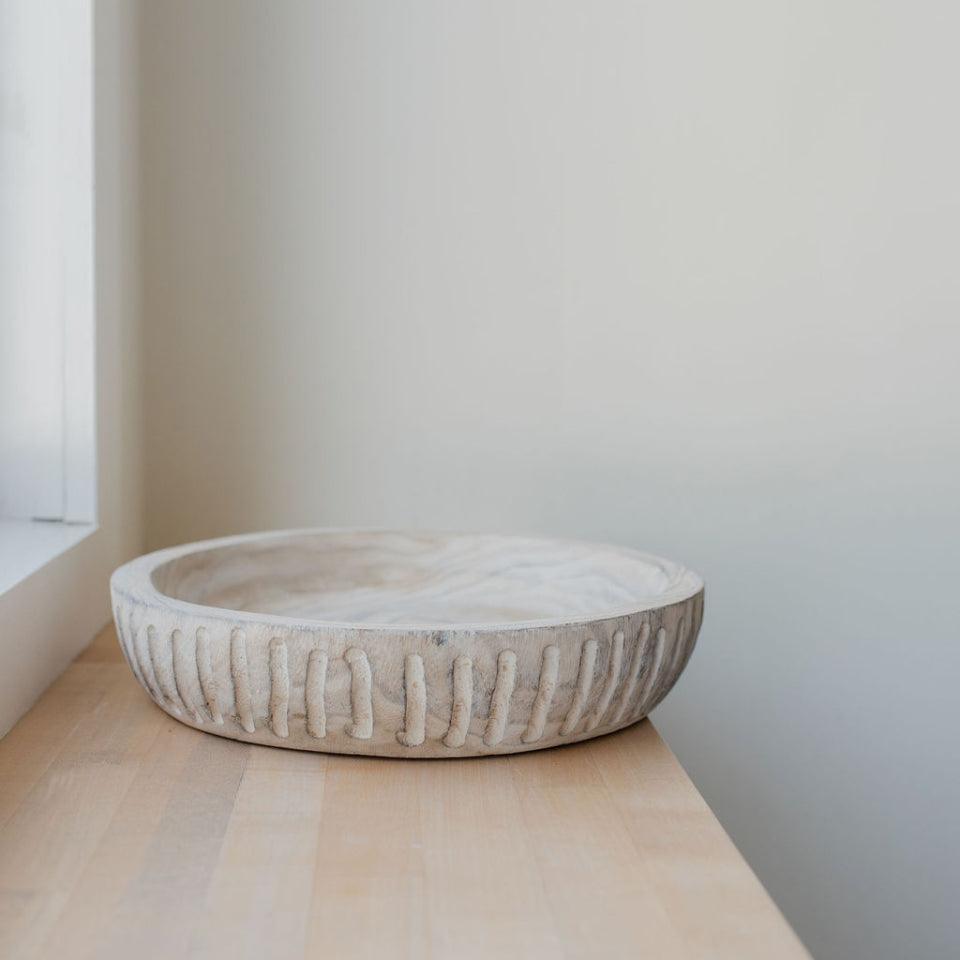 escapade white washed wooden bowl on wooden surface natural light coming from window off frame