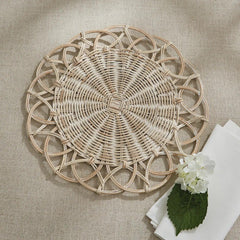 rattan charger plate of natural woven table cloth two white folded napkins bottom right and white flowers atop napkins