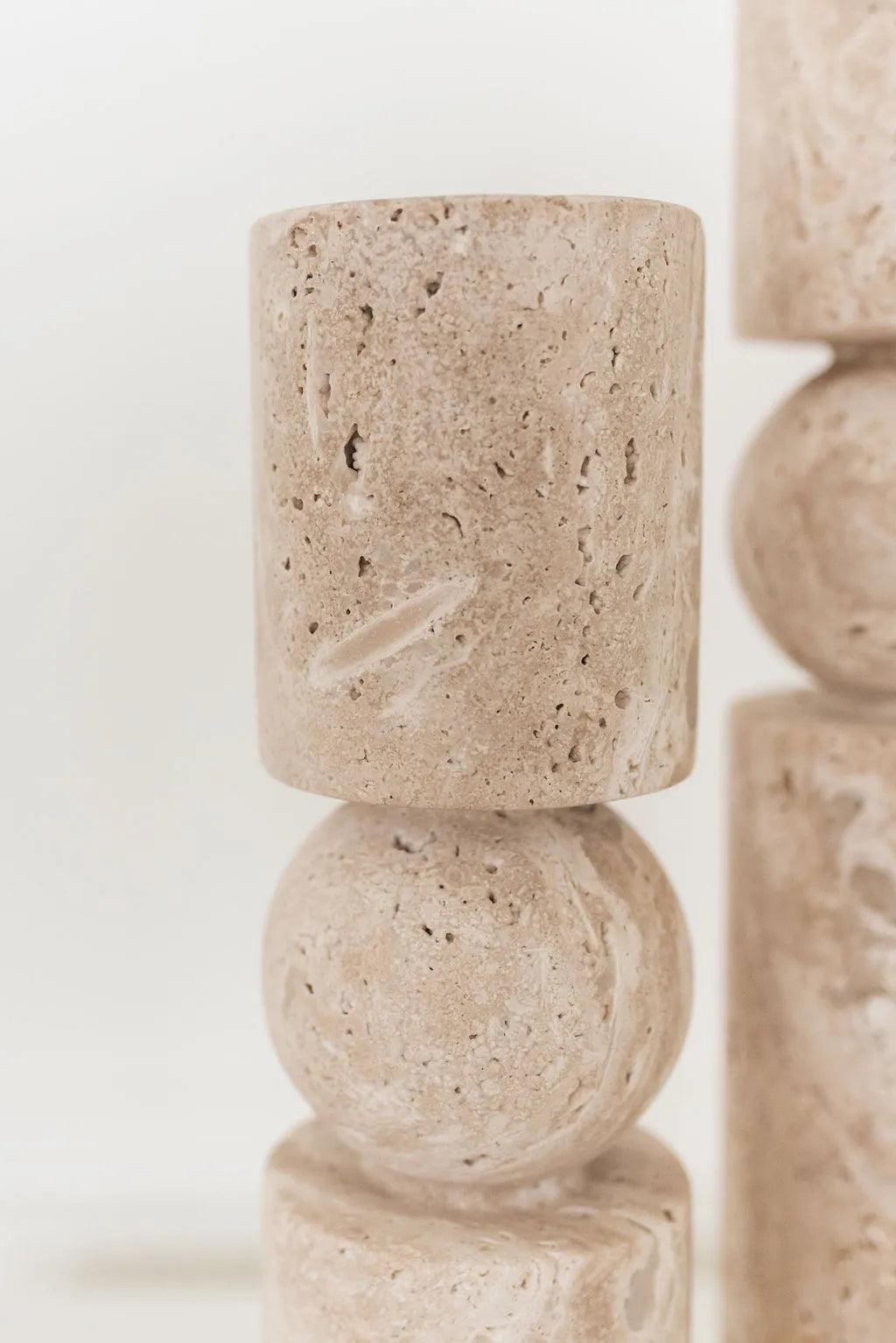 close up picture of a beige short travertine stone candle holder with a white background